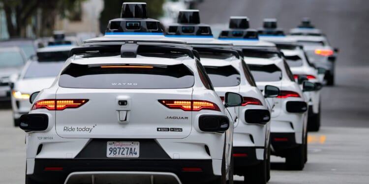 A line of Waymo robot axis drives through North Beach on July 7, 2026 in San Francisco.