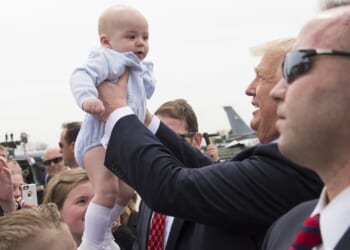 President Donald Trump holds a baby in a crowd