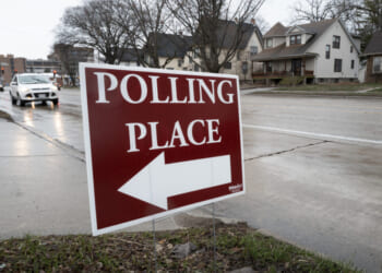 A sign reading POLLING PLACE, drawing the reader to consider the poll taken this month that indicates Alfonso's lead.