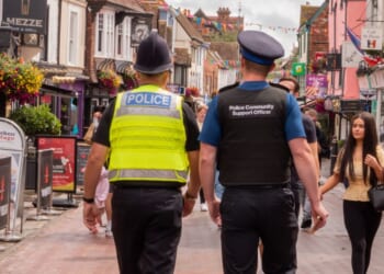 A policeman and a police community support officer walking down a busy street in Canterbury, Kent, United Kingdom, on Aug. 7, 2021.
