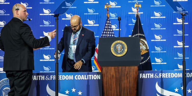 White House teleprompter operators, including Gabriel Perez, set up a teleprompter before President Donald Trump speaks at the Faith & Freedom Coalition's 2026 Policy Conference at the Washington Hilton on June 26, 2026, in Washington, D.C.