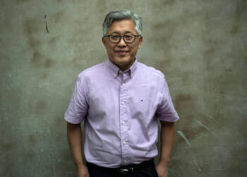 Pastor Ezra Jin stands against a grey background.