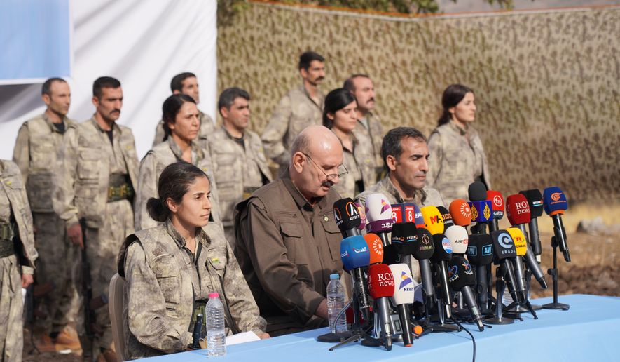 Kurdistan Workers' Party (PKK) fighters, who reportedly withdrew from Turkey with their weapons, stand to attention during a ceremony in the Qandil area of northern, Iraq, Sunday, Oct 26, 2025. (AP Photo/Rashid Yahya, File)