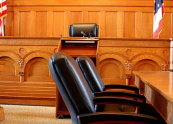 An empty American courtroom is illuminated by light.