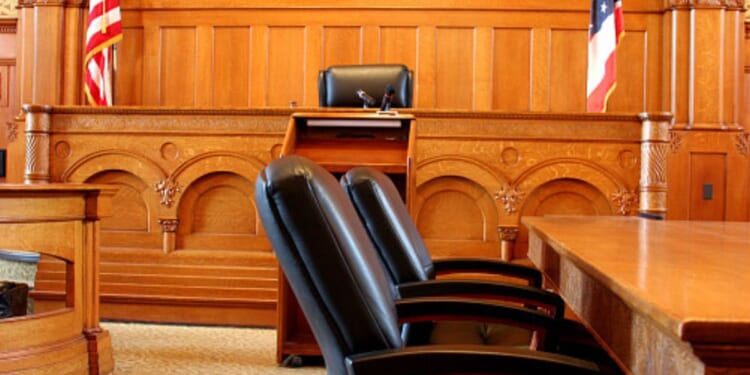 An empty American courtroom is illuminated by light.