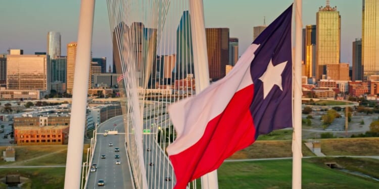 A Texas state flag waves near the Margaret Hunt Hill Bridge in downtown Dallas, Texas.
