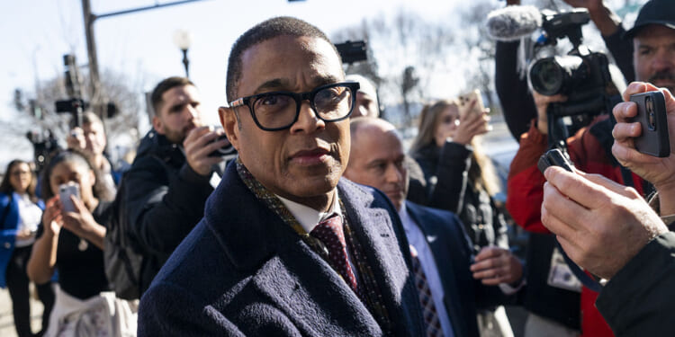 Former CNN host Don Lemon is unlikely to succeed in his motion to dismiss the case for vindictive prosecution, Josh Hammer says. Pictured: Don Lemon, a man in glasses and a dark coat walks outside, surrounded by reporters, cameras, and microphones, with people and trees in the background.