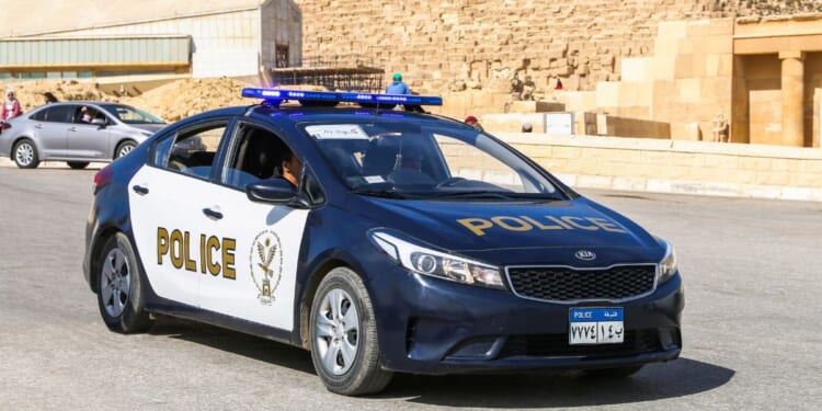 An Egyptian police car sits on a road.