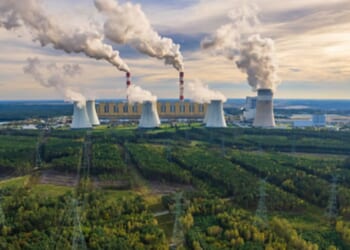 A coal-powered plant in Bełchatów, Poland pumps plumes of smoke into the air above the facility.