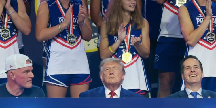 President Donald Trump sits next to sports analyst Pat McAfee as he attends the 2026 Patriot Games at SPIRE Academy on Aug. 11, 2026, in Geneva, Ohio.