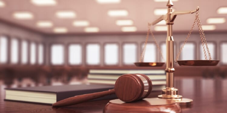 A judge's gavel in an empty courtroom.