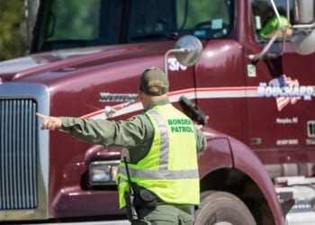 A U.S. Border Patrol agent directs vehicles as they enter a highway checkpoint on Aug. 1, 2018, in West Enfield, Maine.