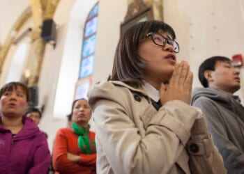 A woman prays in a packed Cathedral in Beijing, China on March 24, 2016.