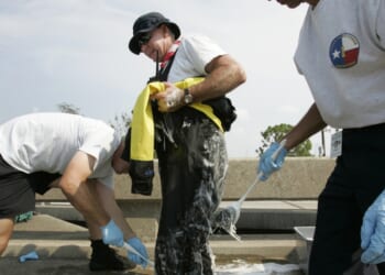 Eddie Mathison of the Texas Task Force 1 Water Search and Rescue Team from Houston, Texas, is scrubbed down with bleach and soap after a day of running boat rescues throughout downtown New Orleans in the aftermath of Hurricane Katrina, on Sept. 5, 2005.