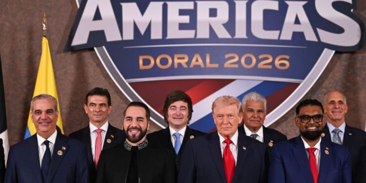 President Donald Trump stands with foreign leaders during a group photograph at the start of the Shield of the Americas Summit at the Trump National Doral Golf Club on March 7, 2026, in Doral, Florida.