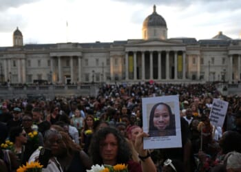 Supporters leave flowers and photographs after taking part in a vigil for late Cambridge professor Jason Arday in Trafalgar Square in central London on Aug. 17, 2026, following his death at age 41.