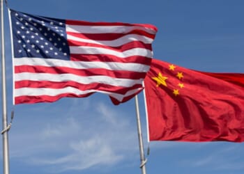 An American flag and Chinese flag wave in strong winds during the afternoon.