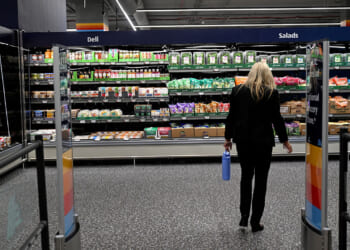 A woman walks near food on display in an Aldi grocery store in New York City, June 17, 2026. REUTERS/Vincent Alban/File Photo