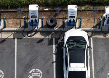In an aerial view, an electric vehicle charges at an EVgo electric charger on March 30, 2026, in Monrovia, California.