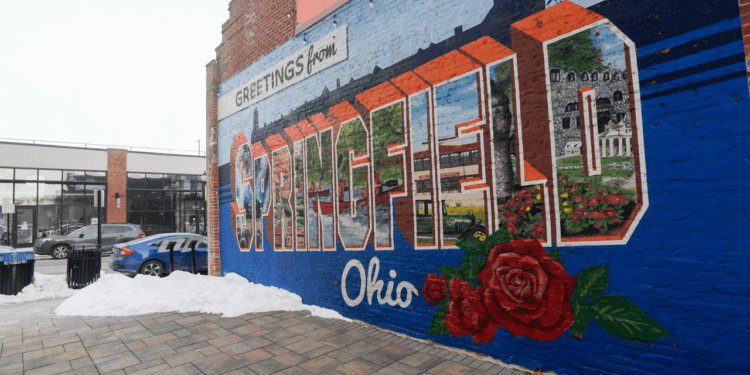 A vibrant mural on a brick wall reads “Greetings from Springfield, Ohio."