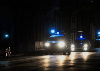 Police lights flash on a dark road in Havana on March 21, 2026.