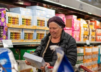 A woman checks a box of cookies while shopping at a Costco Wholesale store on April 13, 2024, in Colchester, Vermont.