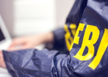 An FBI agent types on a computer.