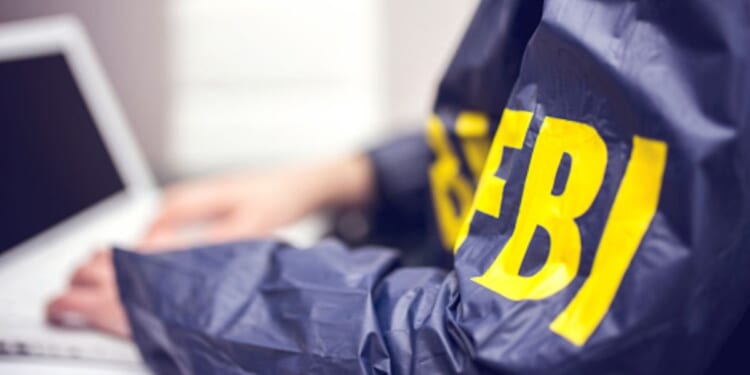 An FBI agent types on a computer.