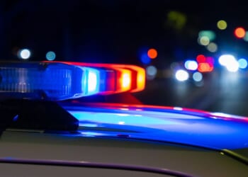 A crime scene in a city at night with blue and red police lights.