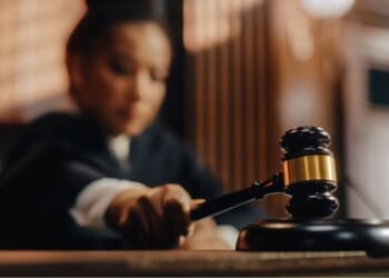 A Judge slams a gavel on a wooden block.