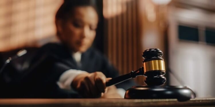 A Judge slams a gavel on a wooden block.