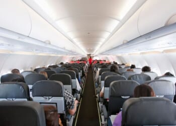 Passengers inside the cabin of a commercial airliner during flight.
