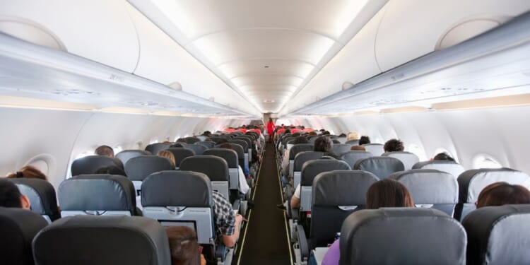 Passengers inside the cabin of a commercial airliner during flight.