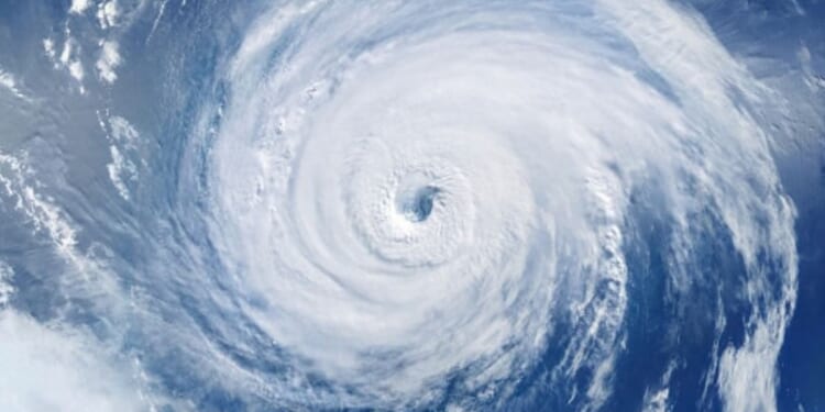 A hurricane is pictured as winds and clouds circle around the eye of the storm.