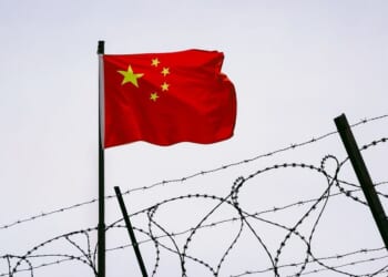 Prison bars with a Chinese flag.