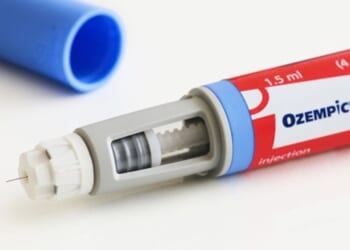 An Ozempic pen is pictured on a white table.