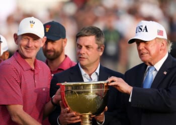 Captain Brandt Snedeker of the U.S. team lifts the trophy after their 17-13 win during the trophy ceremony as President Donald Trump looks on following the Sunday's Singles on day four of the Presidents Cup 2026 at Medinah Country Club on Sept. 27, 2026, in Medinah, Illinois.