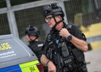 An armed police man mans a roadblock at the entrance to the RAF Fairford air base in England during a counter-terrorism investigation on Sept. 27, 2026.