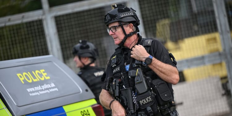 An armed police man mans a roadblock at the entrance to the RAF Fairford air base in England during a counter-terrorism investigation on Sept. 27, 2026.