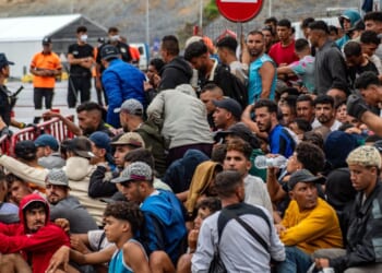 A large group of migrants crowd outside the entrance of the Loma del Colmenar reception center, waiting for admission, in Ceuta on Sept. 1, 2026.