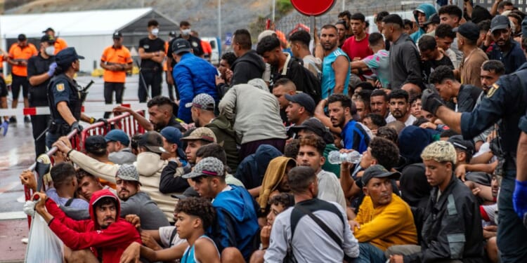 A large group of migrants crowd outside the entrance of the Loma del Colmenar reception center, waiting for admission, in Ceuta on Sept. 1, 2026.