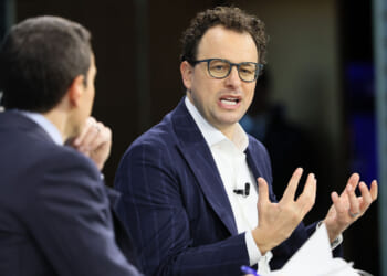 Dario Amodei and another man sit and talk during an interview or panel discussion.