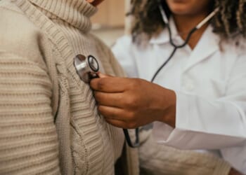 A doctor puts a stethoscope over a patient’s heart.