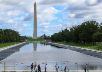 Visitors walk past the reflecting pool as it is refilled on Monday, Oct. 12, 2026.