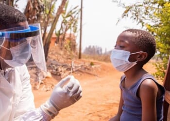 A young child in Africa is given a shot for Ebola.