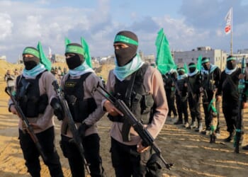 Palestinian Hamas fighters gather at the site of the handing over of the bodies of four Israeli hostages in Khan Yunis in the southern Gaza Strip on Feb. 20, 2025.
