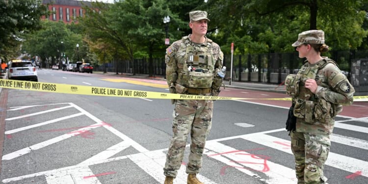 U.S. National Guard members stand by a police line after a car crashed into a barricade near the White House in Washington, D.C., on Sept. 19, 2026.