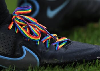A pair of Nike cleats are adorned with rainbow laces in a file photo from a Premier League soccer match in London in November 2021.