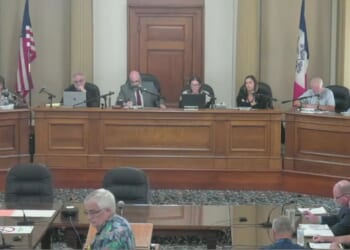 New Life Center pastor Rick Bick, foreground, in flowered shirt, urged the Ottumwa, Iowa, City Council to rebuke a satanic prayer offered moments earlier as an invocation offered by a member of the Satanic Temple of Iowa.
