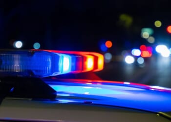 A crime scene in a city at night with blue and red police lights.